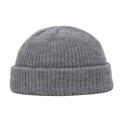 A Wool Knitted Skull Cap Beanie made of grey knit fabric, showcased on a white background.