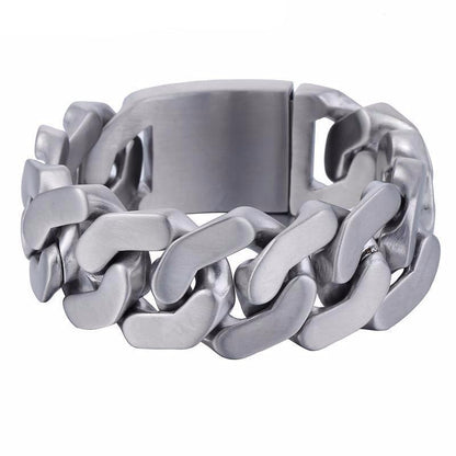 The Stainless Steel Heavy Thick Chain Bracelet boasts a chunky silver design with a width of 1 inch and a thickness of 0.2 inches. This men's accessory features a robust interlocking pattern, complemented by a secure metal clasp, and is rust-resistant for lasting wear.
