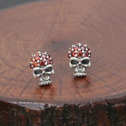 A pair of Fashion Skull Stud Earrings with red crystals.